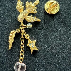 Kirk’s Folly’s Dove “peace” pin with embellished heart, star, leaf, and crystal.